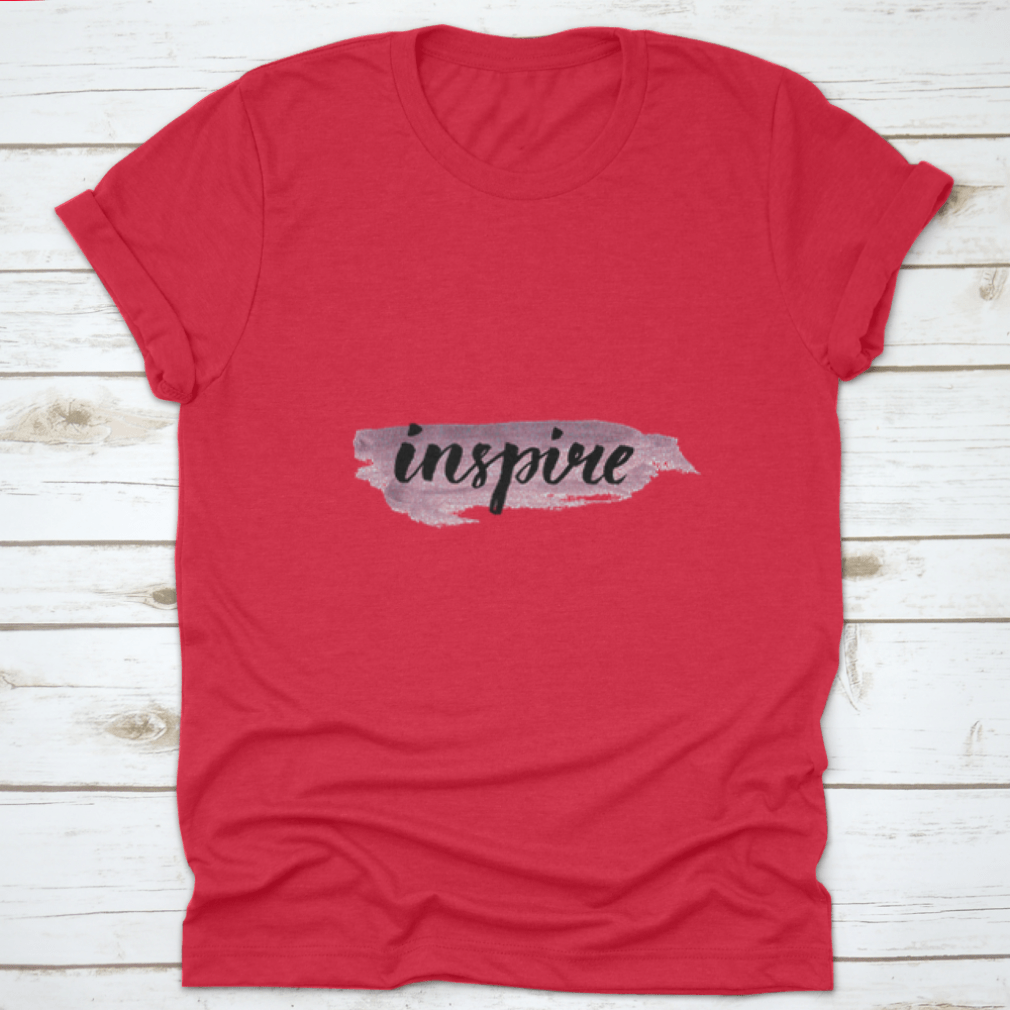 Inspire Calligraphy Word Handwritten on Silver Paint, showcasing elegant lettering on a stylish fabric background.