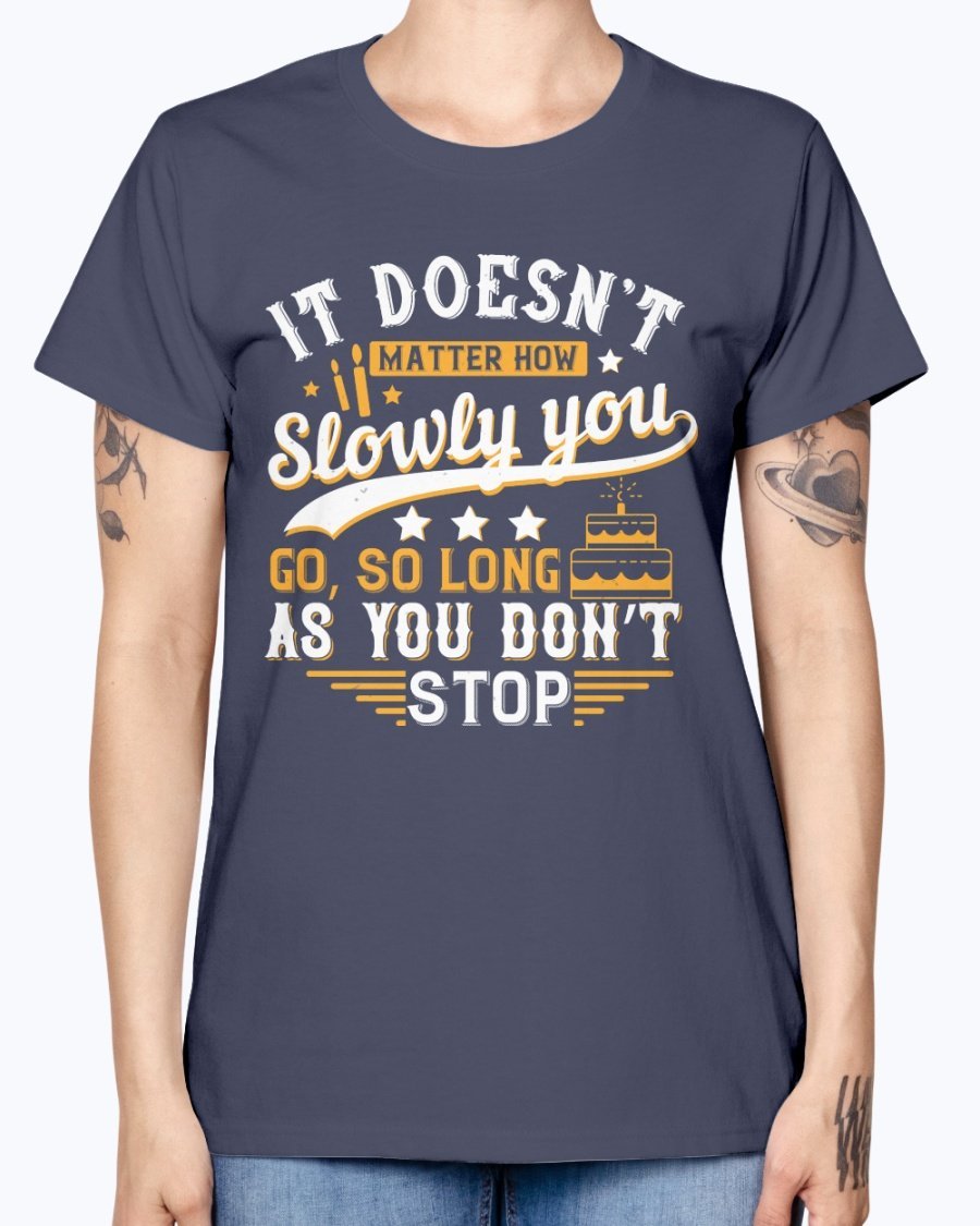 A stylish Missy T-Shirt featuring the motivational quote 'It doesn’t matter how slowly you go, so long as you don’t stop' in a soft cotton blend.