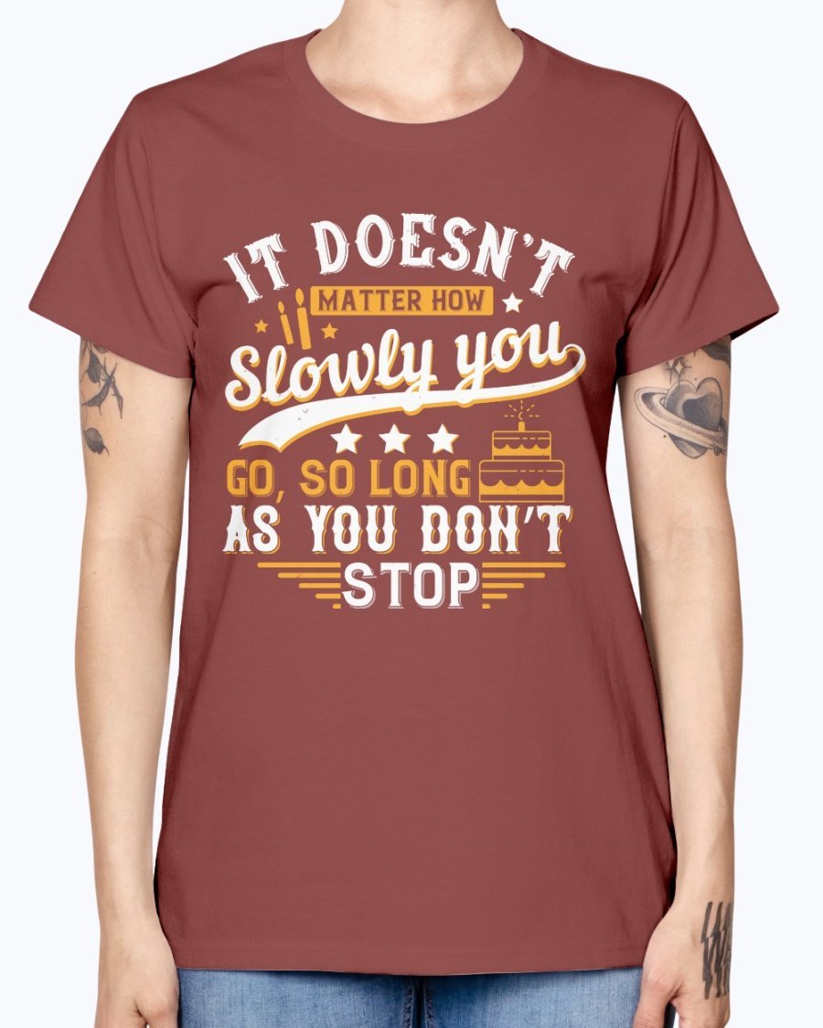 A stylish Missy T-Shirt featuring the motivational quote 'It doesn’t matter how slowly you go, so long as you don’t stop' in a soft cotton blend.