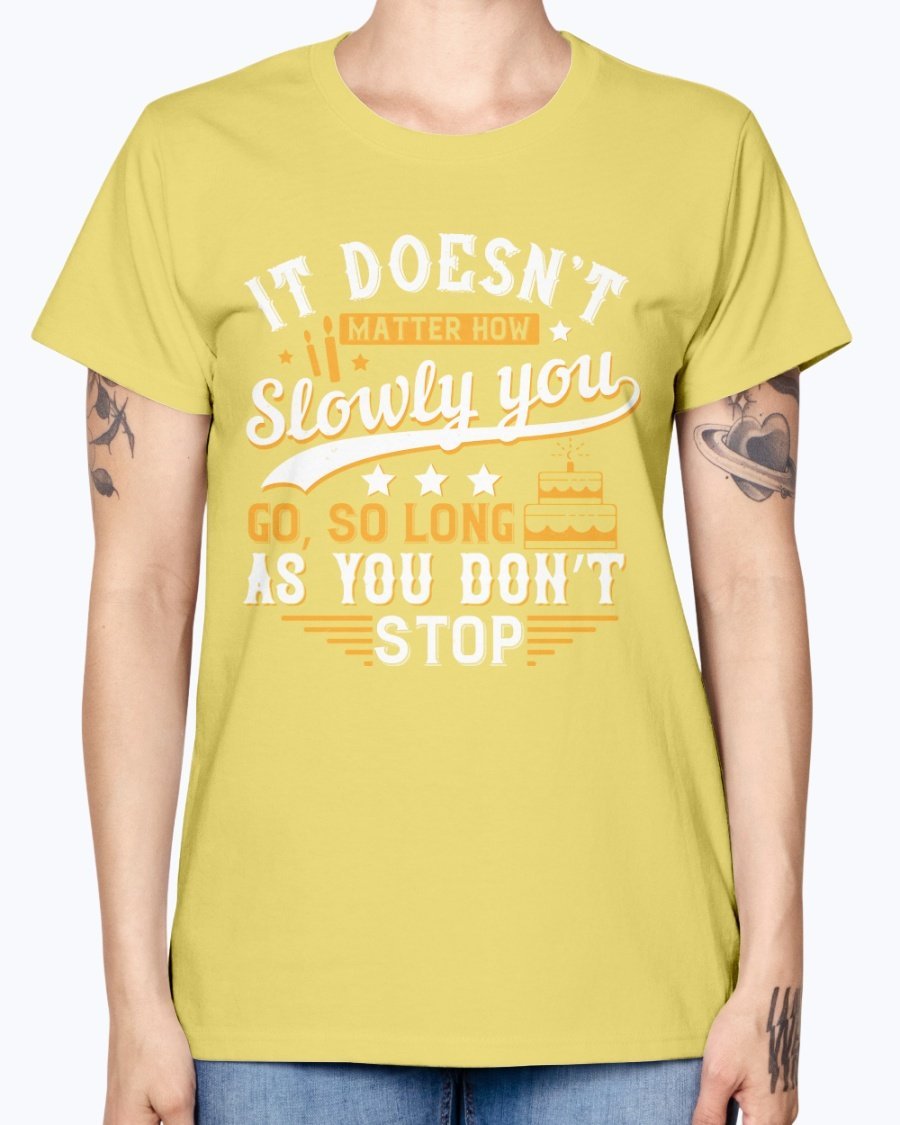 A stylish Missy T-Shirt featuring the motivational quote 'It doesn’t matter how slowly you go, so long as you don’t stop' in a soft cotton blend.