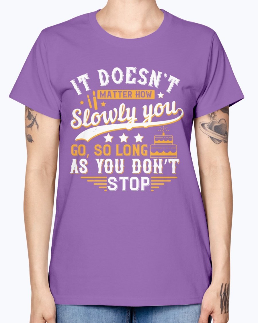 A stylish Missy T-Shirt featuring the motivational quote 'It doesn’t matter how slowly you go, so long as you don’t stop' in a soft cotton blend.