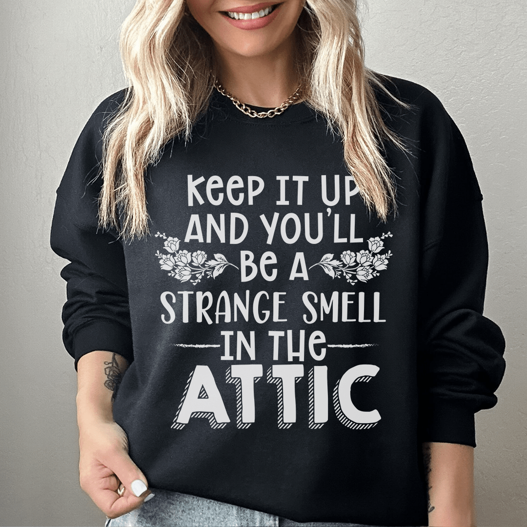 A cozy sweatshirt featuring a unique design titled 'Keep It Up & You'll Be A Strange Smell In The Attic', made from cotton/poly fleece blend.