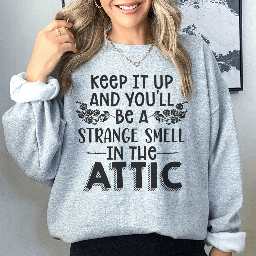 A cozy sweatshirt featuring a unique design titled 'Keep It Up & You'll Be A Strange Smell In The Attic', made from cotton/poly fleece blend.