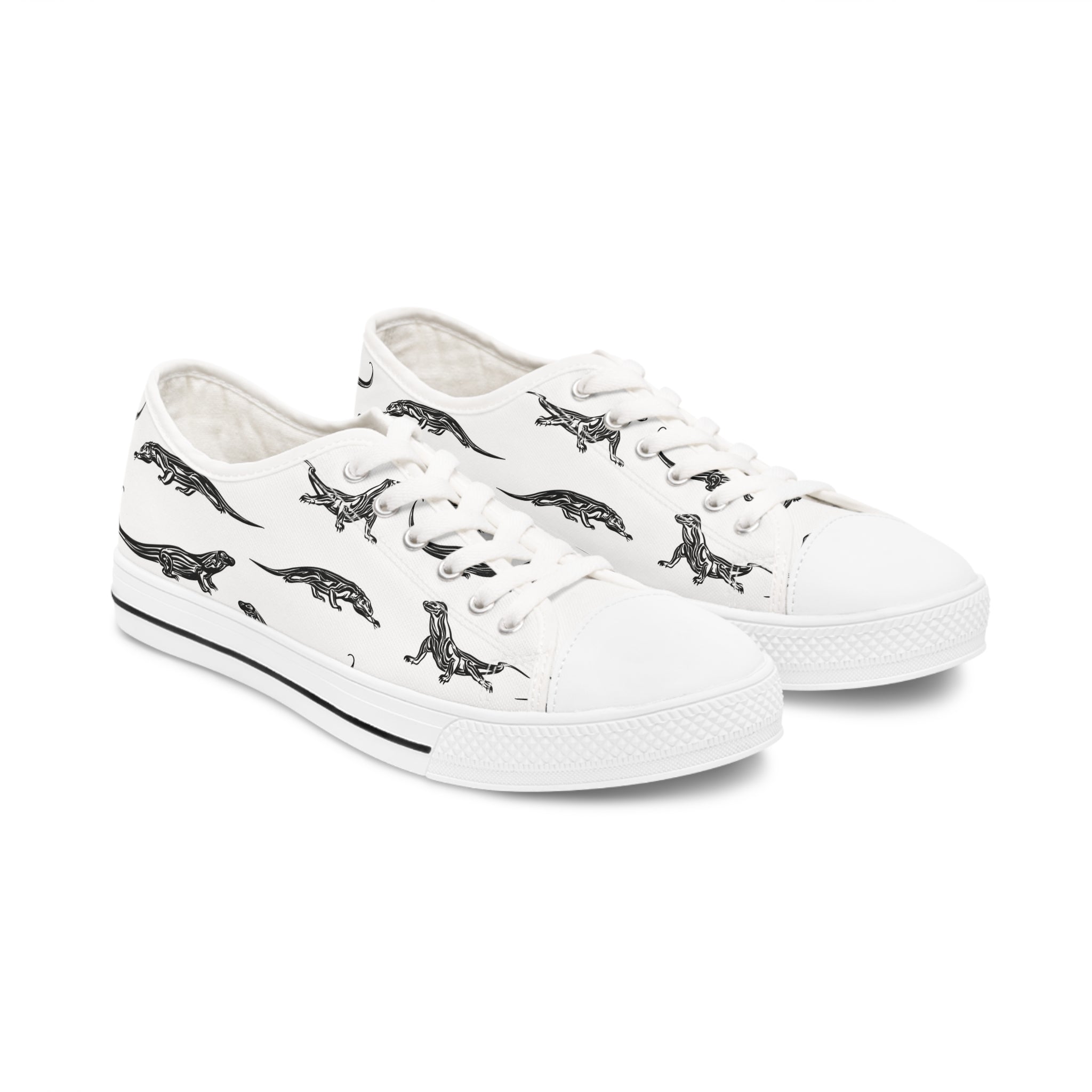A pair of Komodo Dragon Women's Low Top Sneakers in black and white, showcasing breathable polyester canvas and stylish silver metal eyelets.