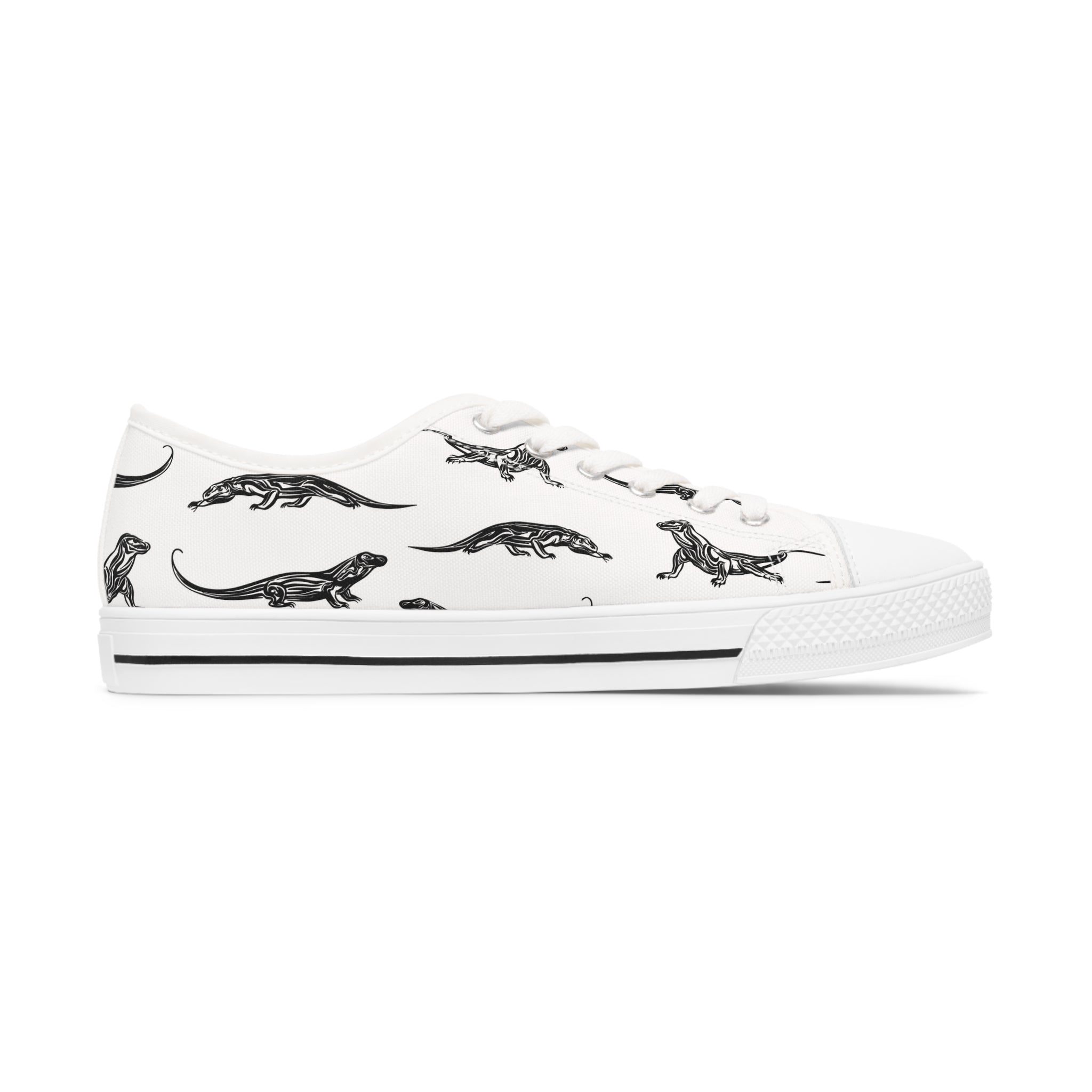 A pair of Komodo Dragon Women's Low Top Sneakers in black and white, showcasing breathable polyester canvas and stylish silver metal eyelets.