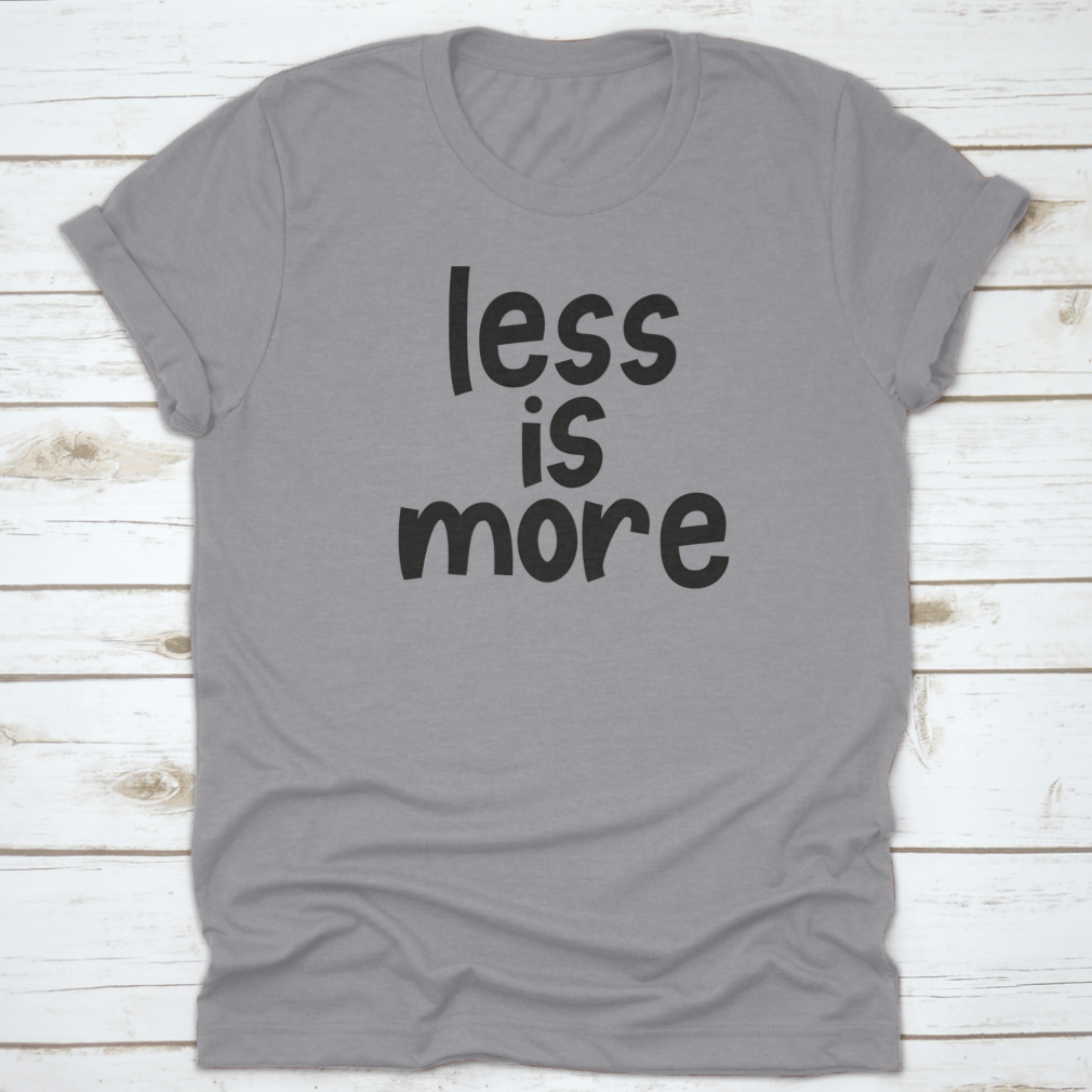 A stylish grey T-shirt featuring the hand-lettered slogan 'Less Is More', promoting zero waste and sustainable fashion.