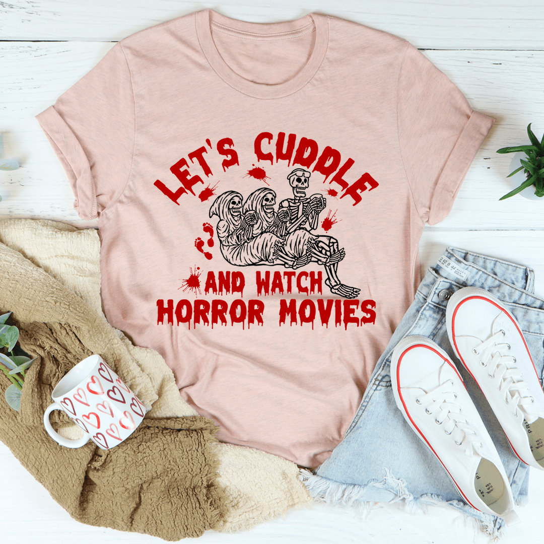 A cozy black t-shirt featuring the phrase 'Let's Cuddle And Watch Horror Movies' in bold white letters, perfect for movie nights.