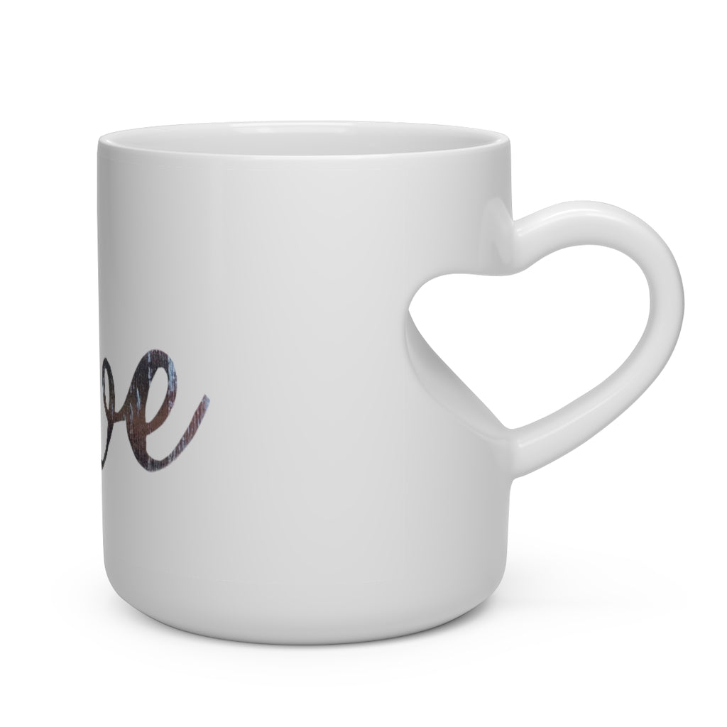 A white ceramic mug shaped like a heart with a heart-shaped handle, perfect for hot beverages.