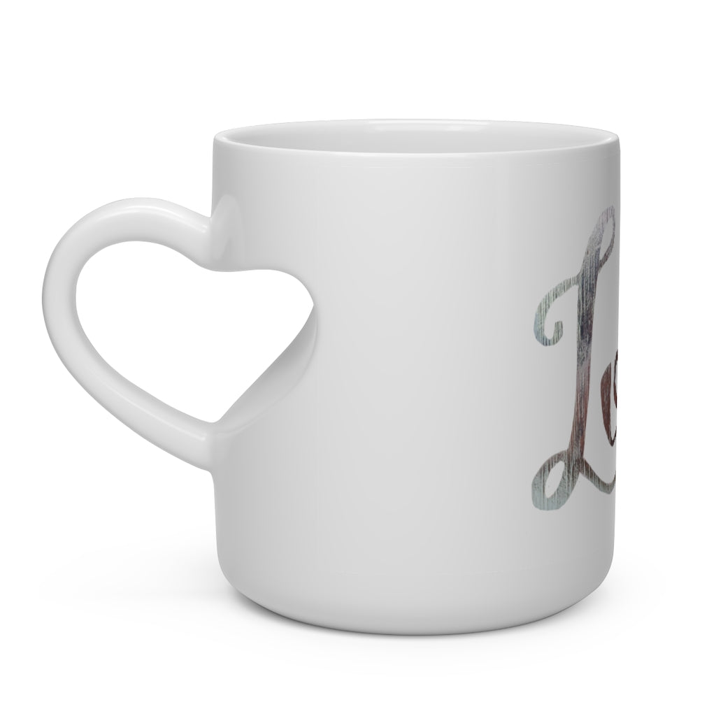 A white ceramic mug shaped like a heart with a heart-shaped handle, perfect for hot beverages.