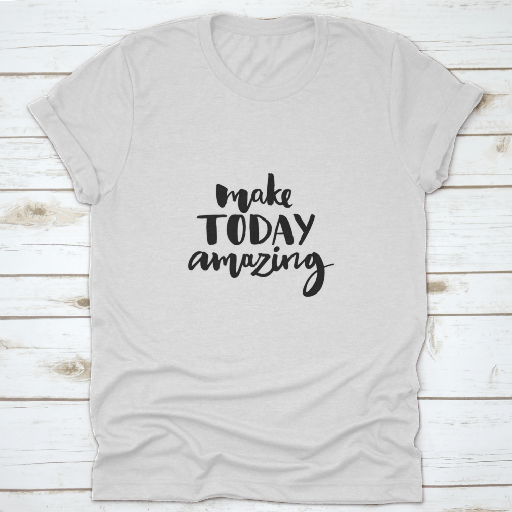 A stylish shirt featuring the handwritten inspirational quote 'Make Today Amazing' in black ink on a soft fabric background.
