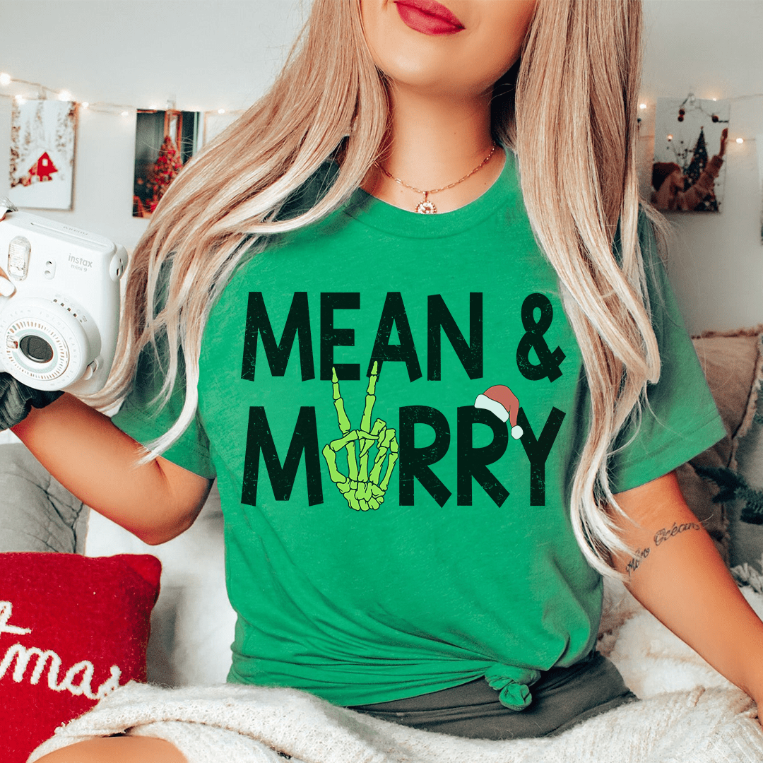 A festive Mean & Merry Tee featuring vibrant holiday-themed graphics, made from 100% soft cotton, perfect for Christmas celebrations.