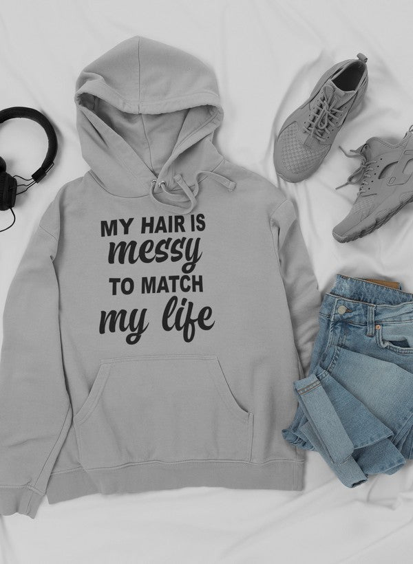 A cozy hoodie featuring the phrase 'My Hair Is Messy To Match My Life', designed by top artists, showcasing a stylish and comfortable fit.