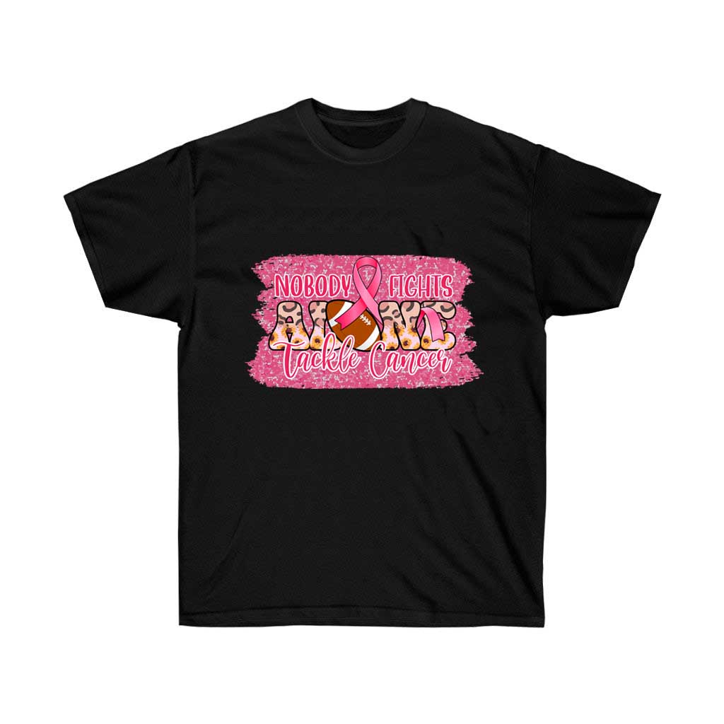A pink t-shirt with the text 'Nobody Fights Alone' and a football graphic, symbolizing support for cancer awareness.