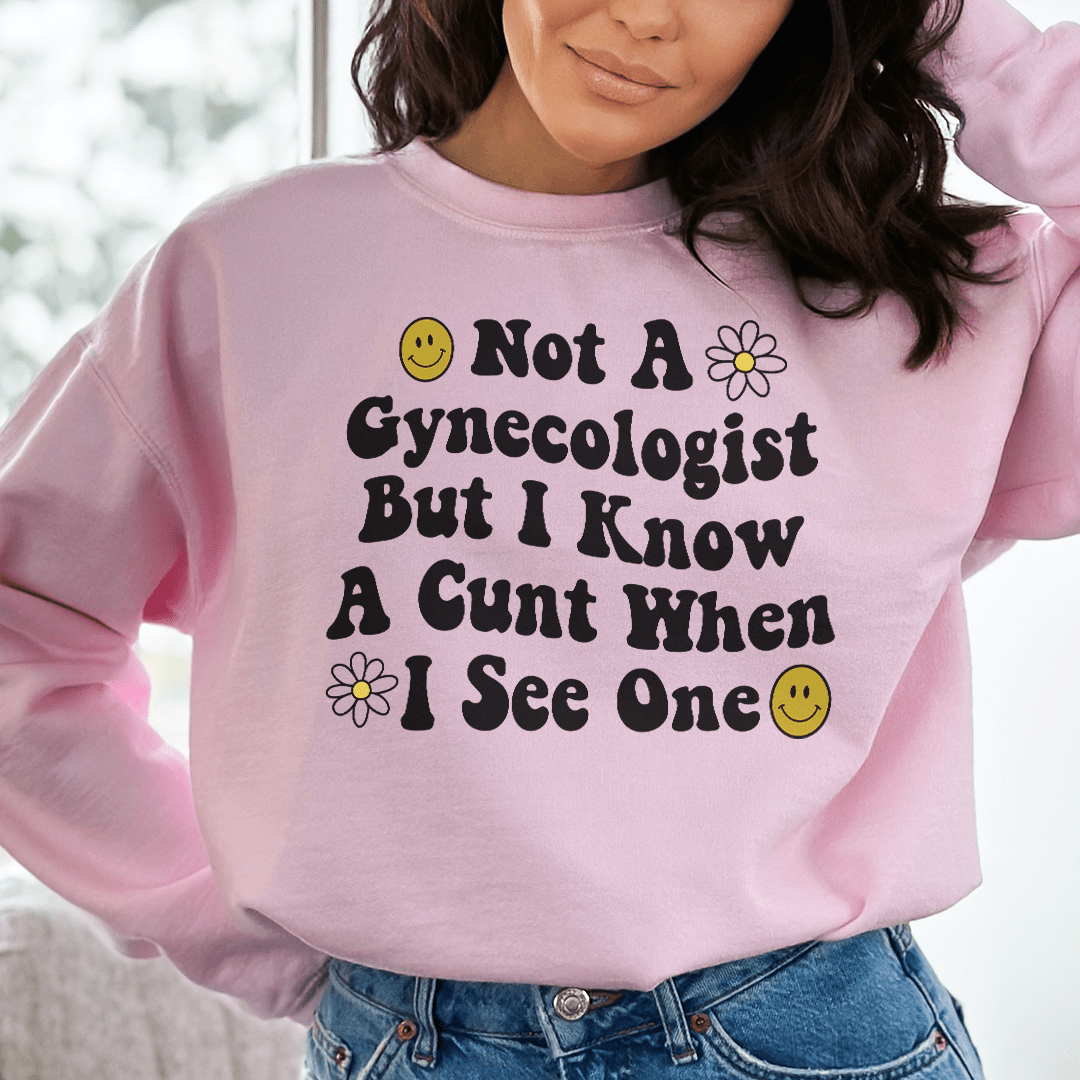 A cozy hoodie with a humorous design that reads 'Not A Gynecologist But I Know A Cunt When I See One', featuring adjustable cuffs and fleece lining.