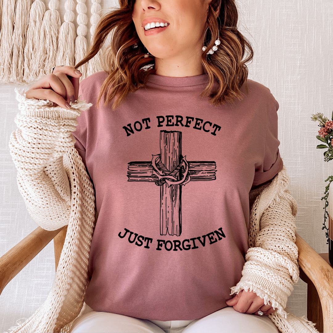 Not Perfect Just Forgiven T-Shirt displayed on a hanger, showcasing its soft fabric and double stitching details.