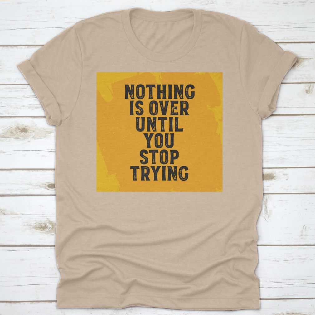 A motivational T-shirt featuring the quote 'Nothing Is Over Until You Stop Trying', made from 100% cotton with a classic fit.