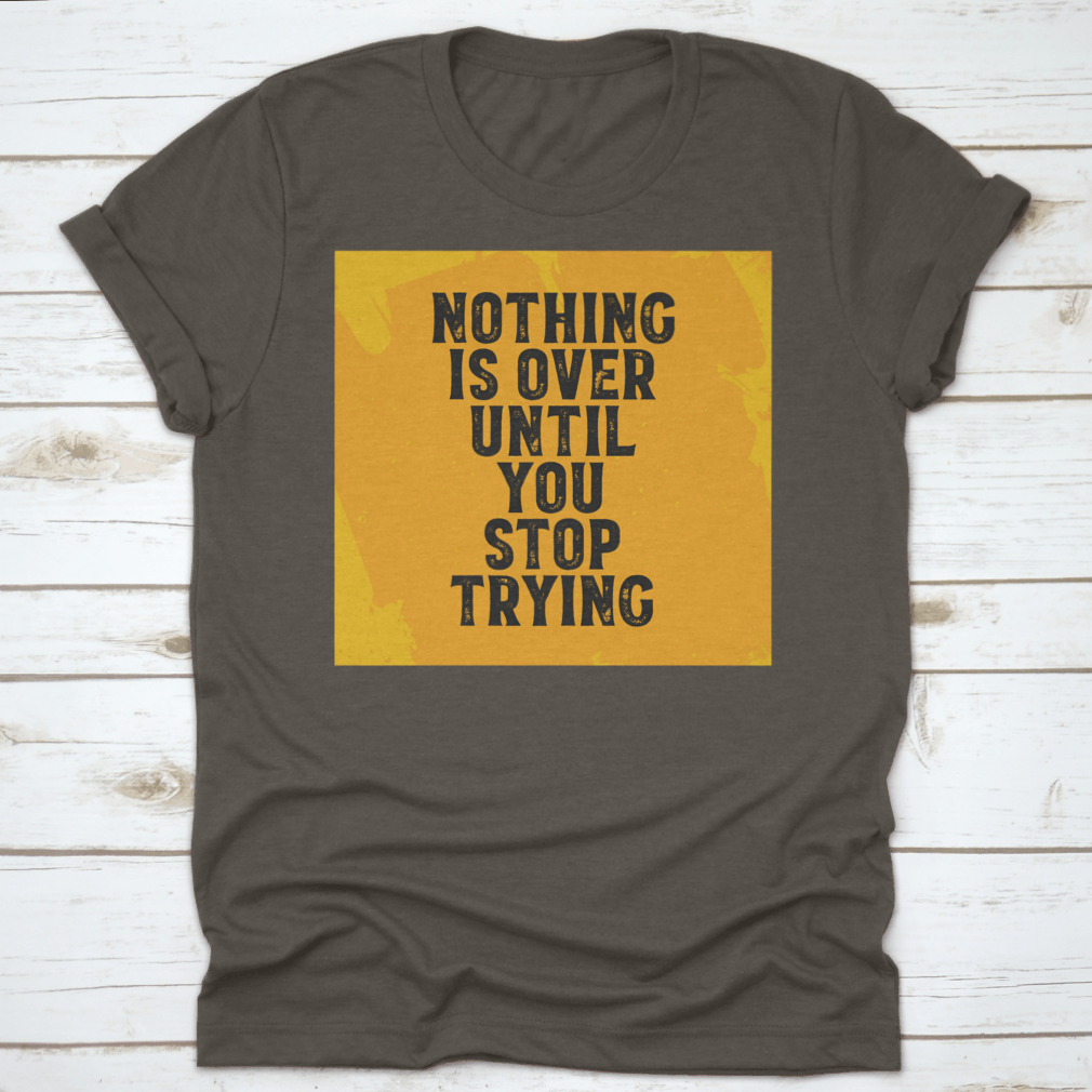 A motivational T-shirt featuring the quote 'Nothing Is Over Until You Stop Trying', made from 100% cotton with a classic fit.