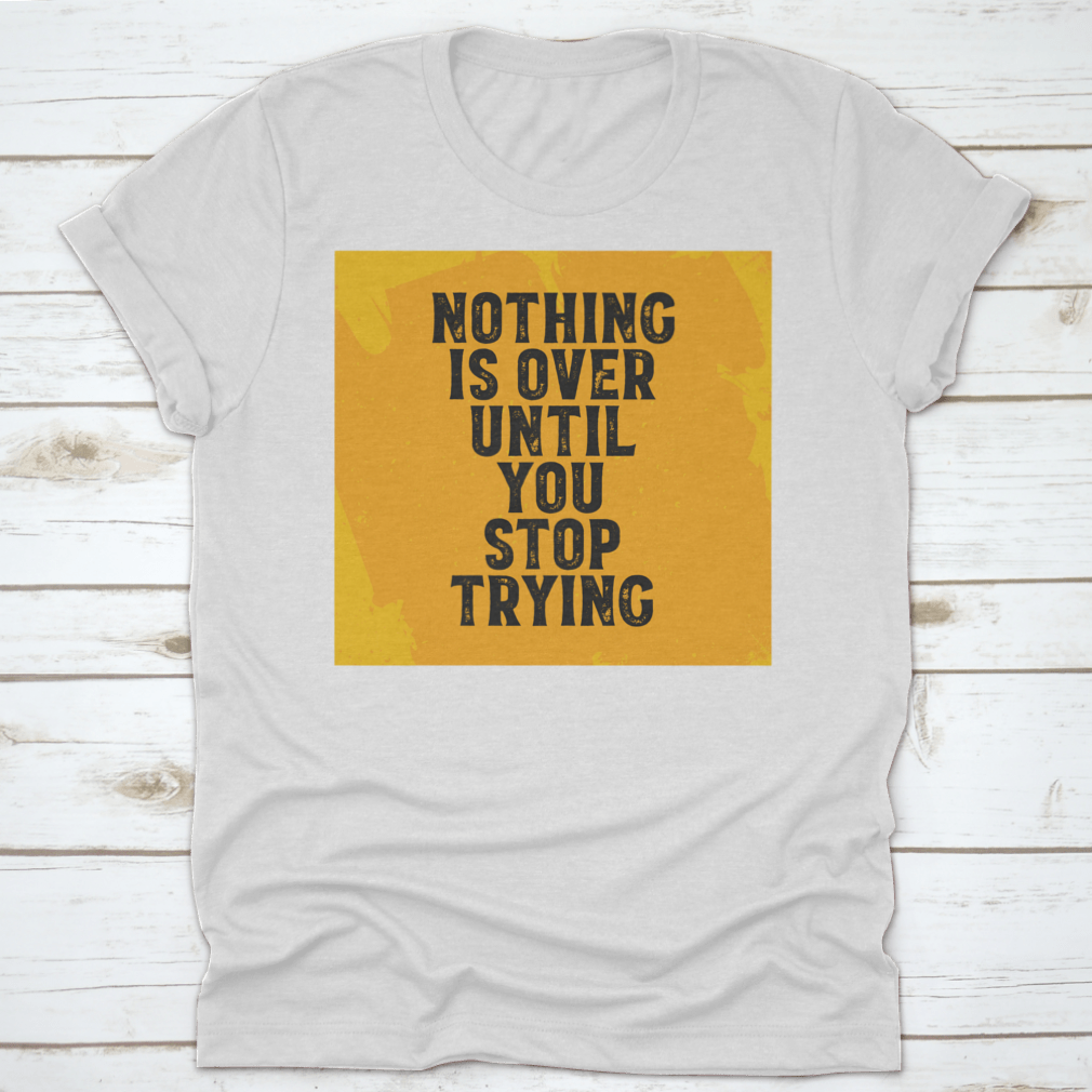 A motivational T-shirt featuring the quote 'Nothing Is Over Until You Stop Trying', made from 100% cotton with a classic fit.