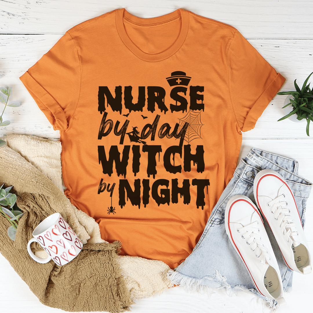 A black t-shirt featuring the phrase 'Nurse By Day Witch By Night' in stylish lettering, showcasing a blend of professionalism and mystique.