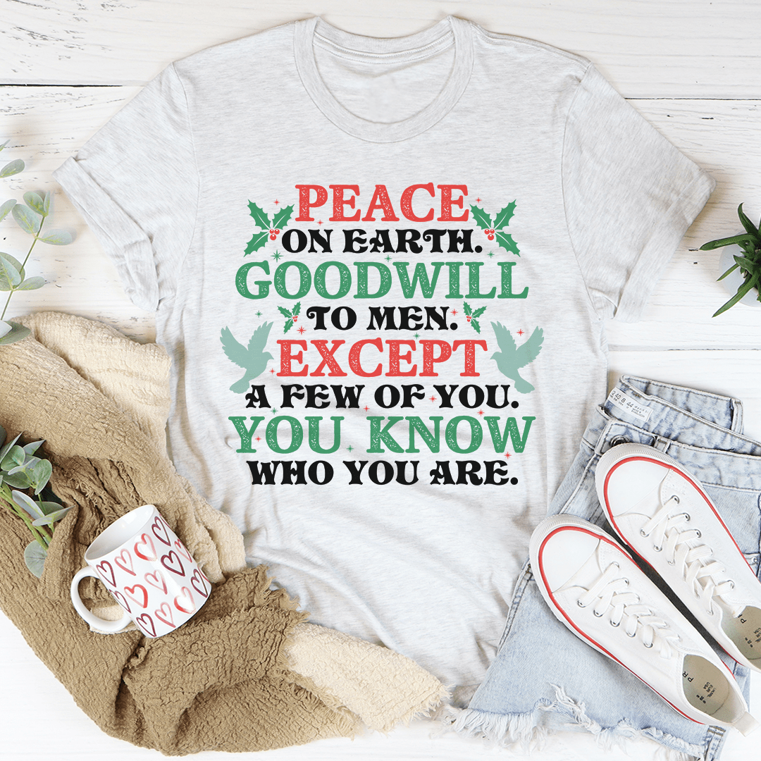 A festive Peace On Earth Goodwill To Men Tee featuring a holiday-themed design, made from 100% soft cotton, perfect for Christmas celebrations.