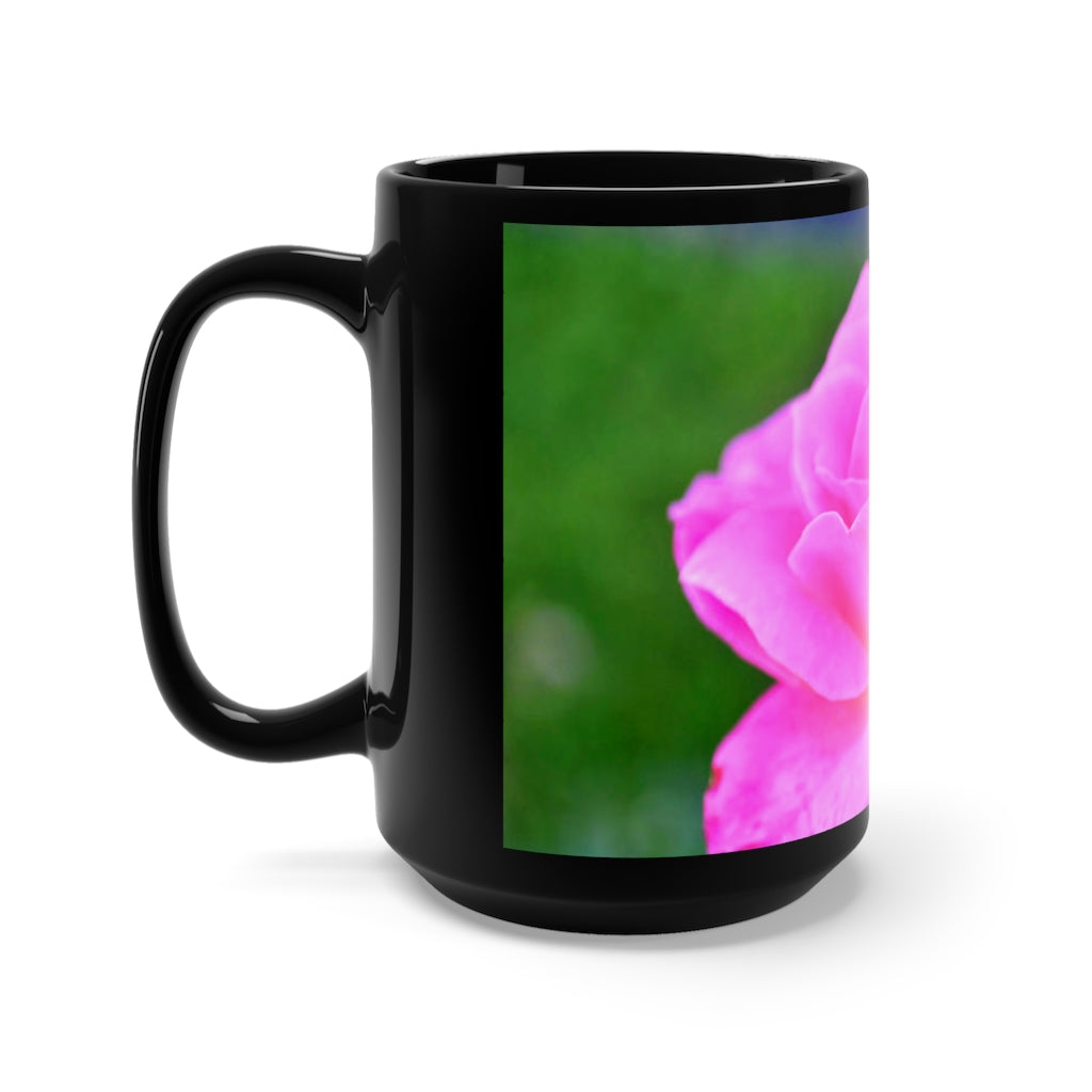 A stylish black ceramic mug featuring a vibrant pink flower design, perfect for coffee and tea lovers.