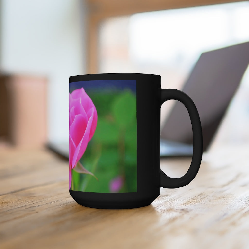A stylish black ceramic mug featuring a vibrant pink flower design, perfect for coffee and tea lovers.