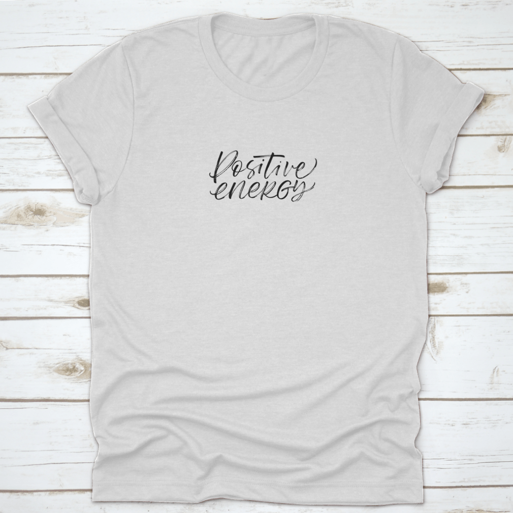 A stylish ink illustration featuring a positive energy phrase in modern brush calligraphy on a soft cotton fabric, showcasing a blend of artistic design and comfort.