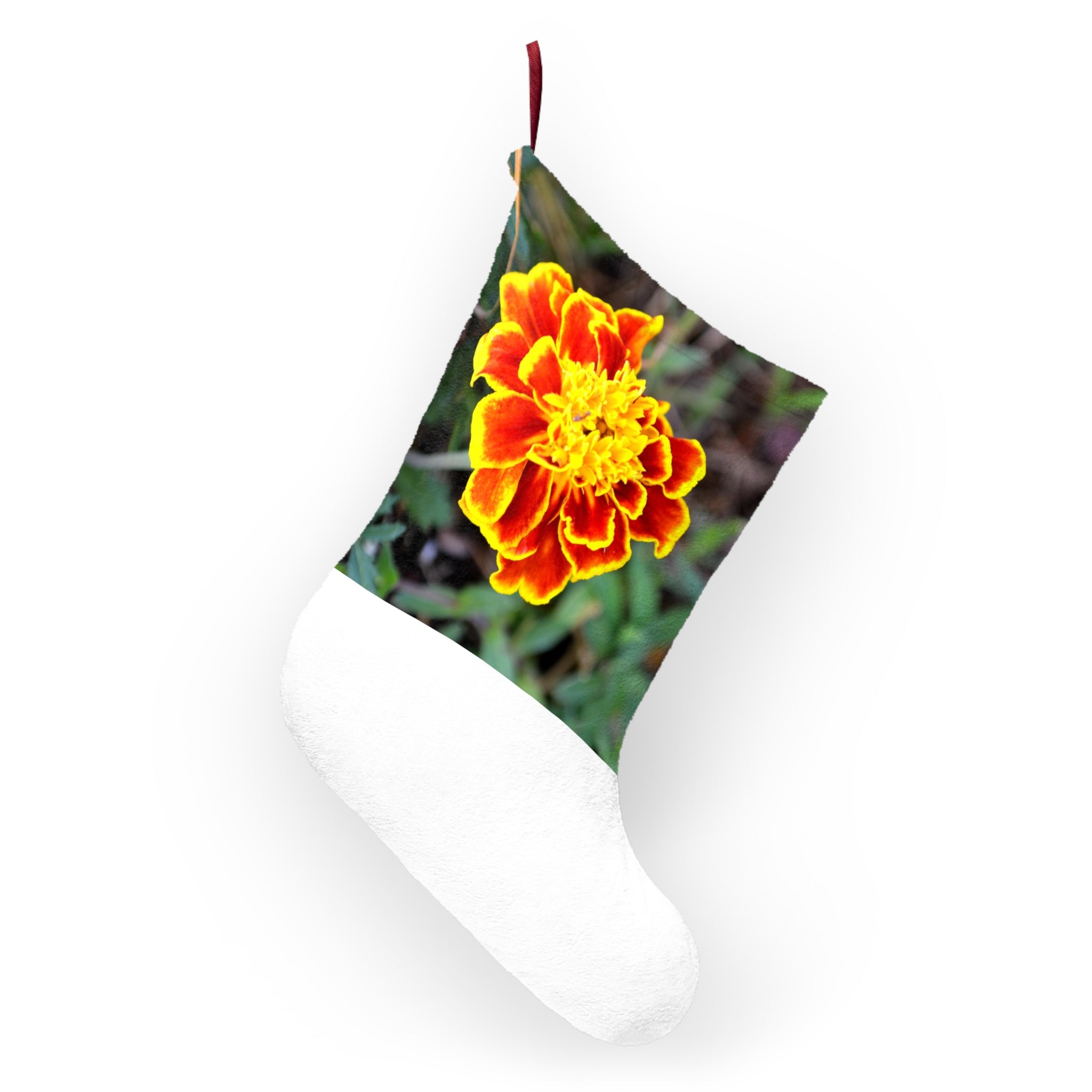 A pair of vibrant red and yellow flower Christmas stockings hanging by a fireplace, showcasing their festive design and soft fleece material.
