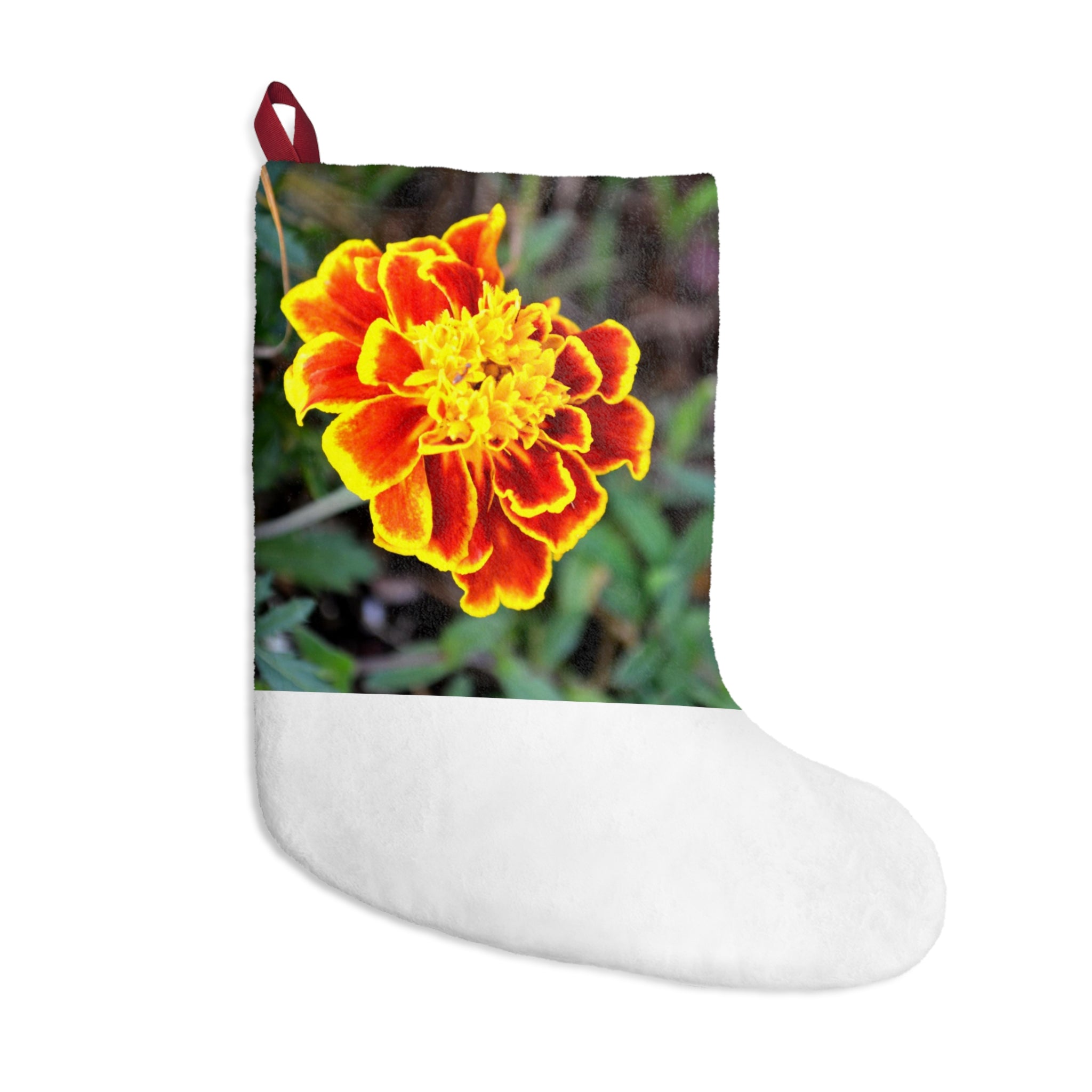 A pair of vibrant red and yellow flower Christmas stockings hanging by a fireplace, showcasing their festive design and soft fleece material.