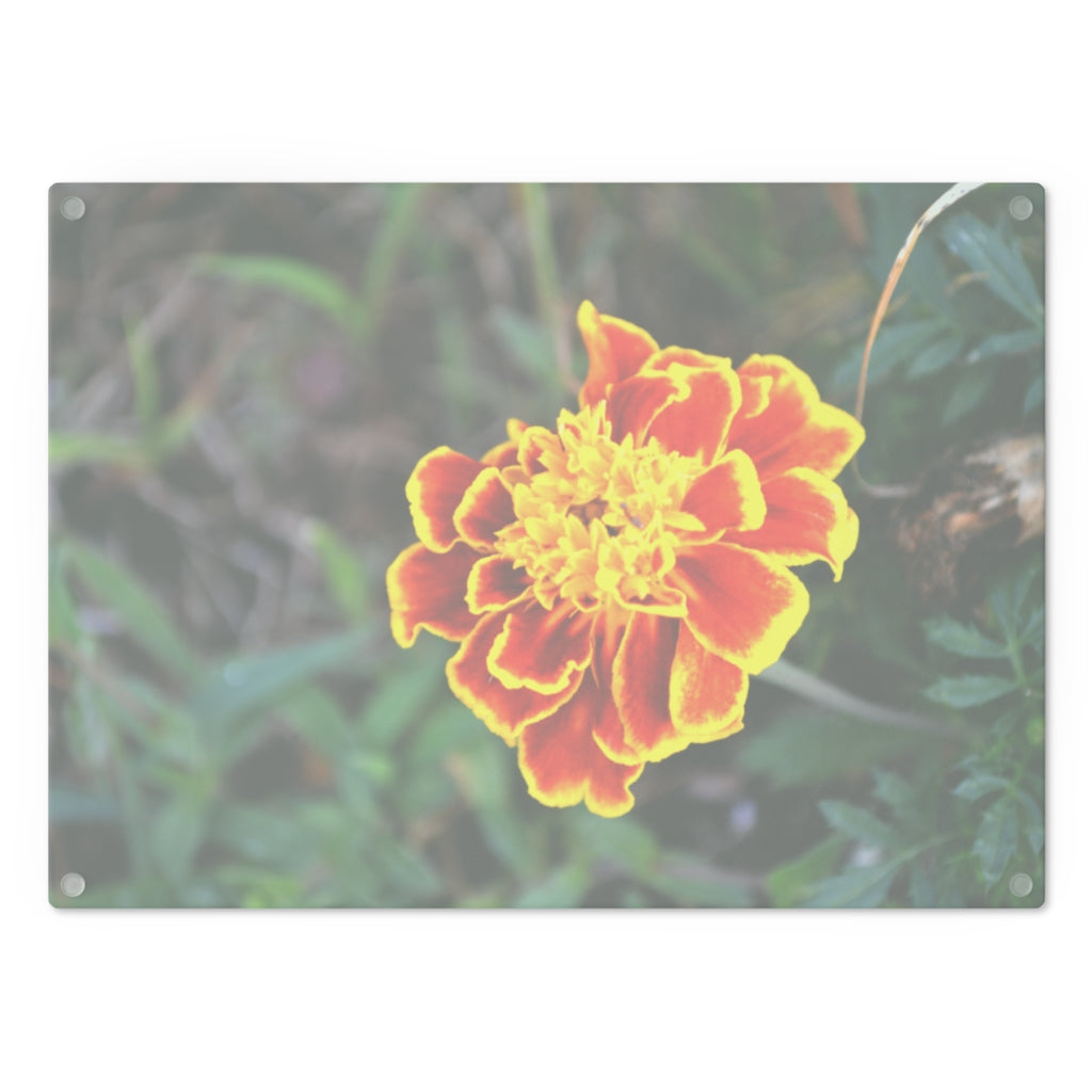 A vibrant red and yellow flower patterned tempered glass cutting board with rubber dots for stability, ideal for kitchen use.