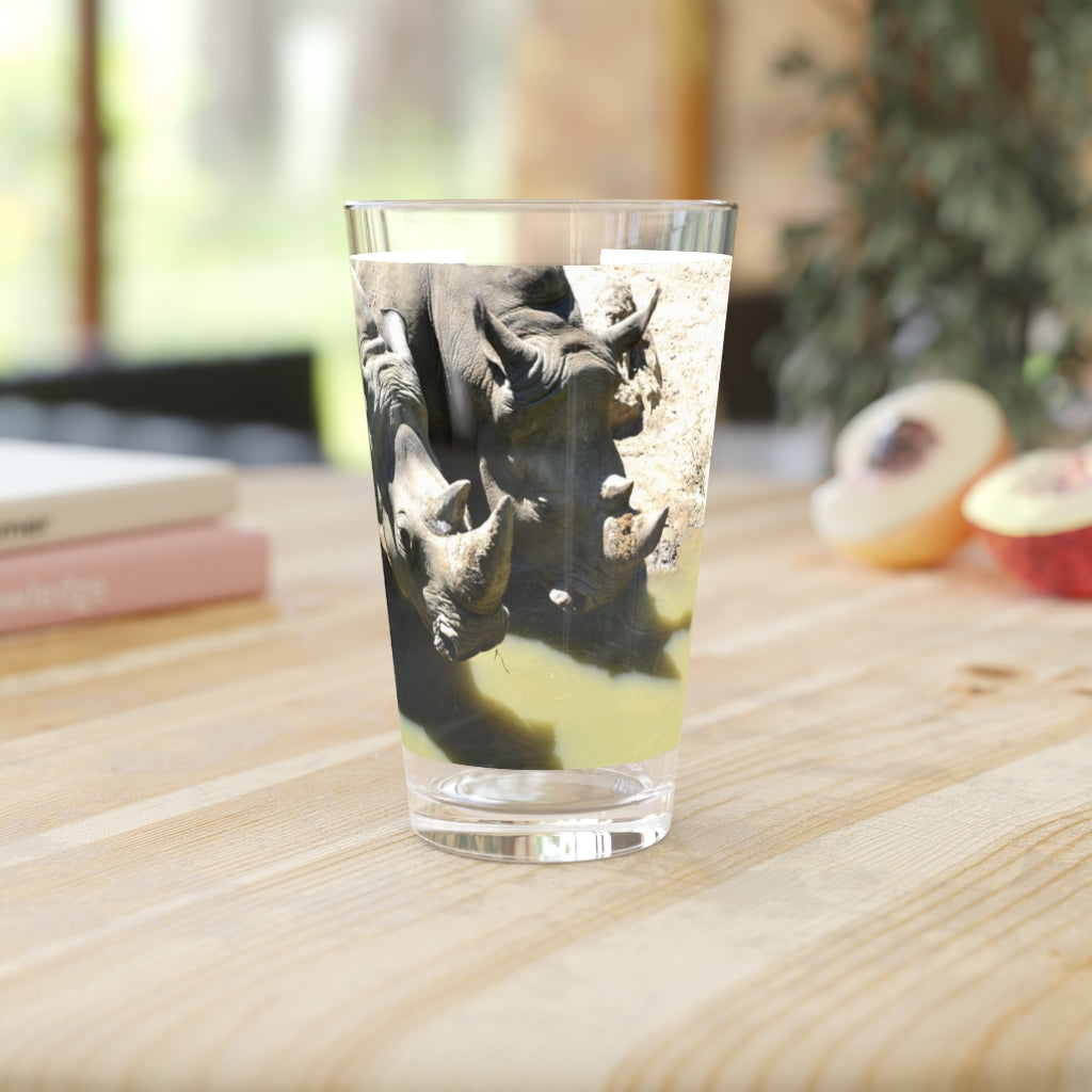 A clear 16oz Rhinos Pint Glass showcasing its sleek design, perfect for personalized drinks.