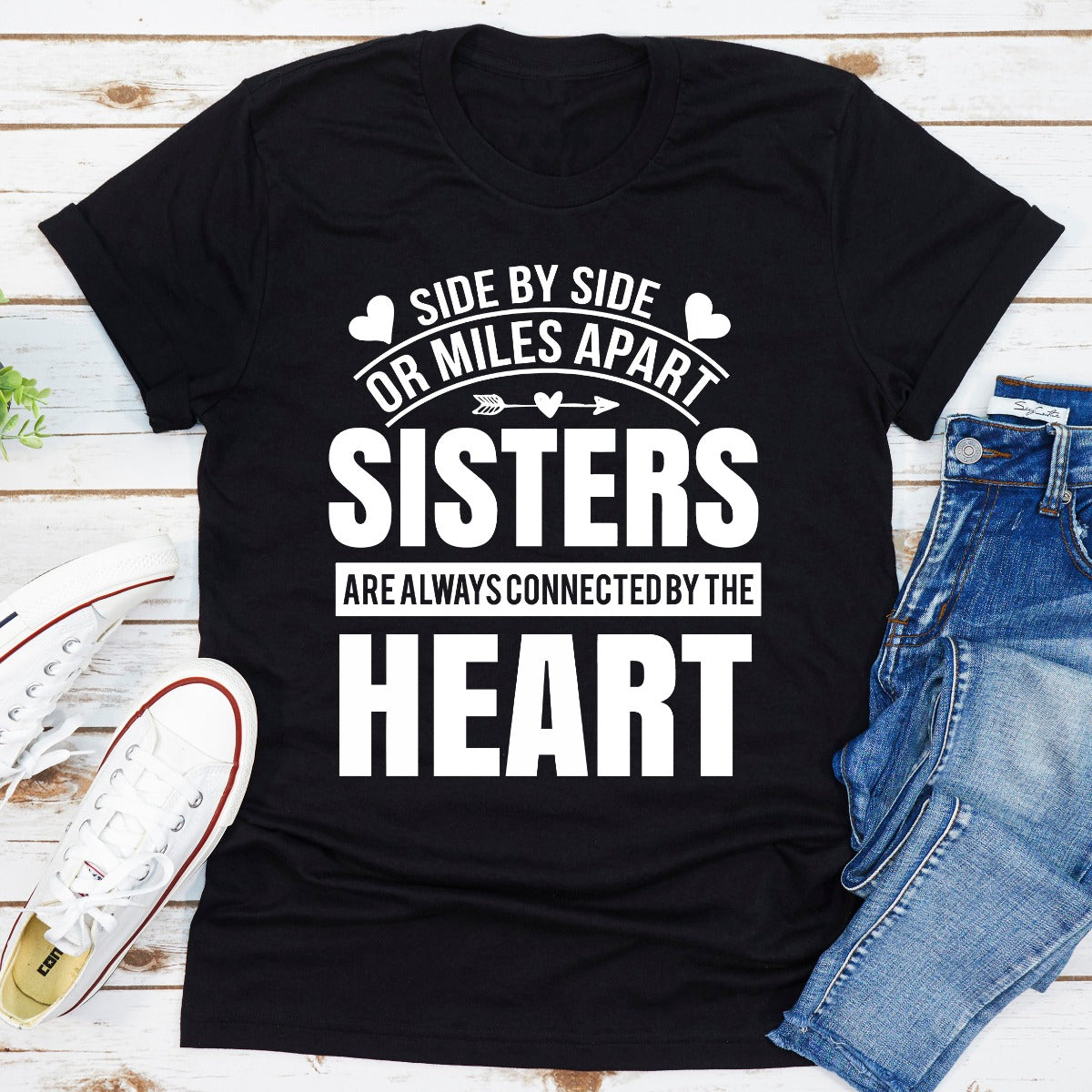 A soft, durable t-shirt featuring the phrase 'Side By Side Or Miles Apart Sisters Are Always Connected By The Heart' in a stylish font.