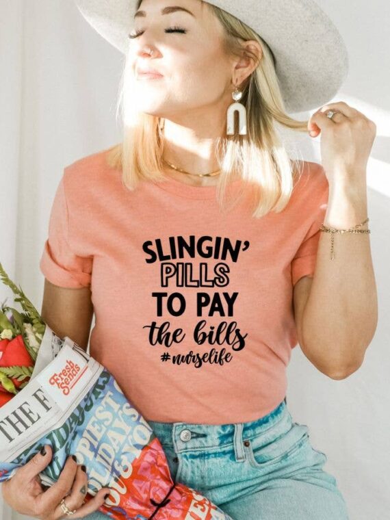 Slingin' Pills To Pay The Bills Nurse Life T-shirt in various sizes, showcasing its soft cotton fabric and vibrant print.