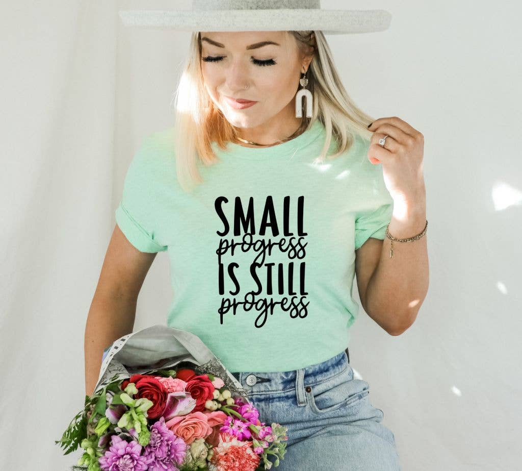 Small Progress Is Still Progress T-shirt made of premium ring spun cotton with a soft textile flex print, available in various sizes.