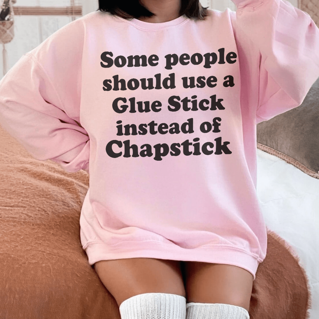 A cozy hoodie featuring the humorous phrase 'Some People Should Use Glue Stick Instead Of Chapstick', made from a soft cotton/poly fleece blend.