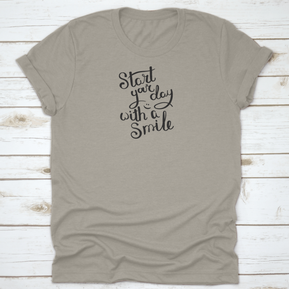 A motivational quote T-shirt featuring the phrase 'Start Your Day With A Smile', made from soft cotton fabric in various colors.