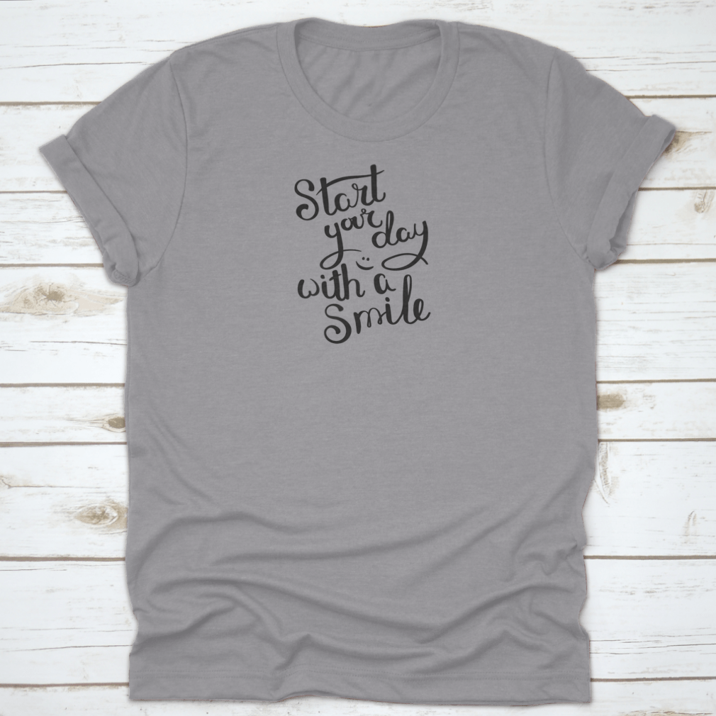 A motivational quote T-shirt featuring the phrase 'Start Your Day With A Smile', made from soft cotton fabric in various colors.