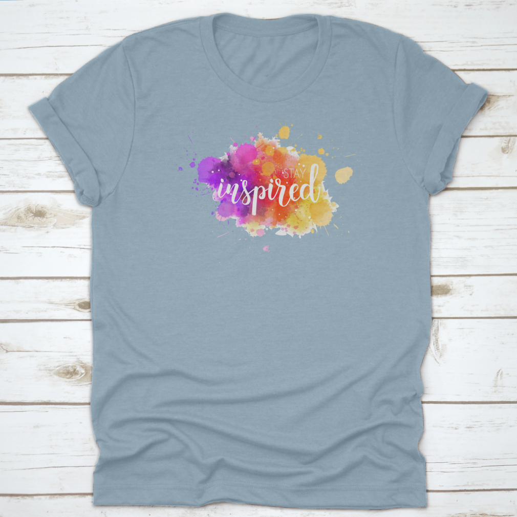 A stylish t-shirt featuring a hand lettering phrase on a vibrant watercolor background, made from 100% cotton for comfort.