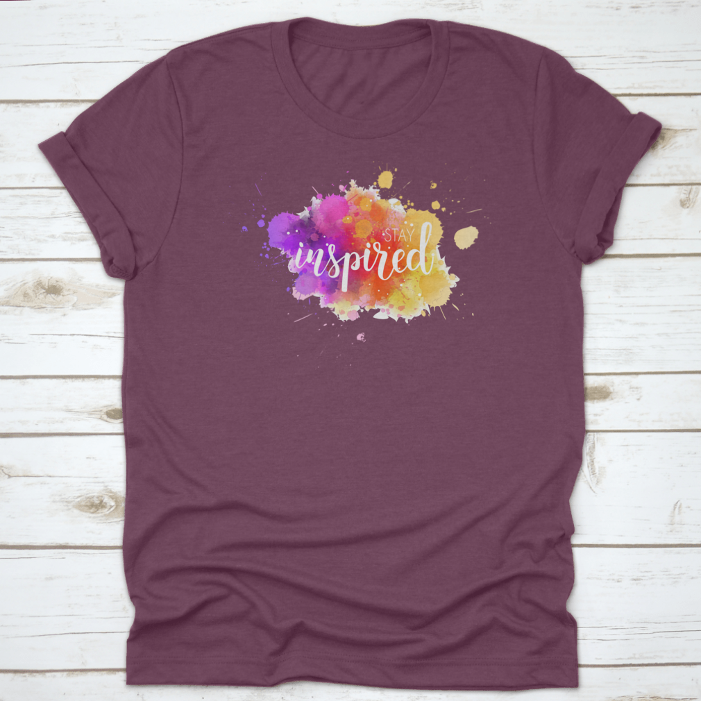 A stylish t-shirt featuring a hand lettering phrase on a vibrant watercolor background, made from 100% cotton for comfort.