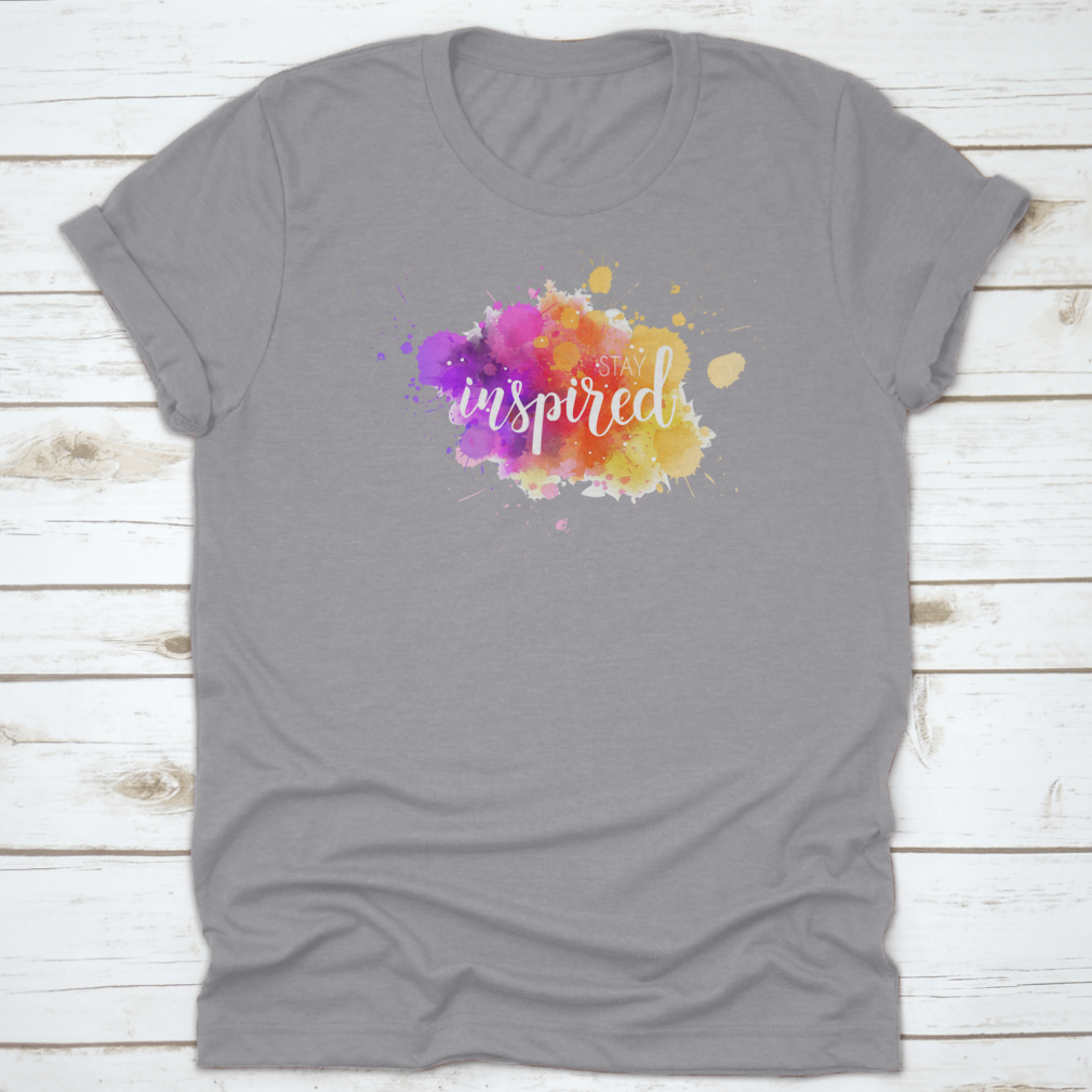 A stylish t-shirt featuring a hand lettering phrase on a vibrant watercolor background, made from 100% cotton for comfort.