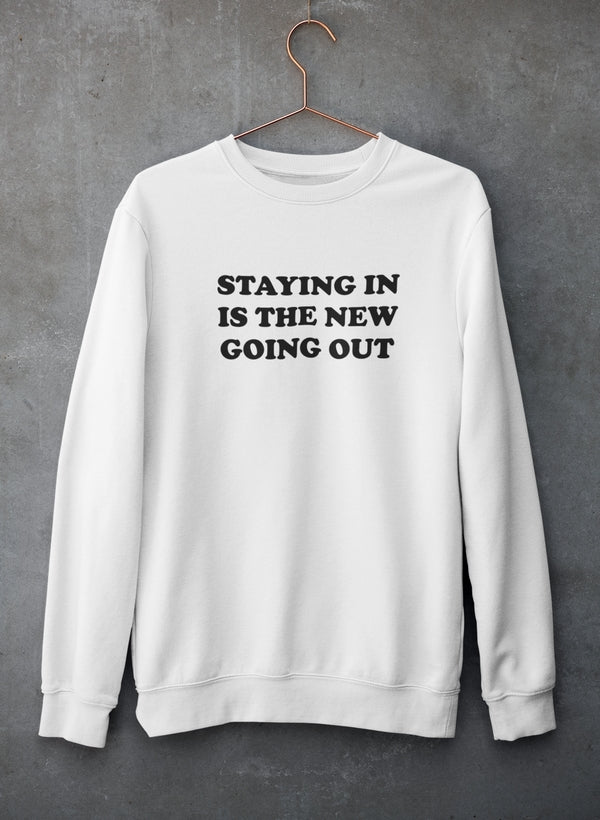 Cozy sweatshirt featuring the phrase 'Staying In Is The New Going Out', designed by top artists, made from cotton/poly fleece blend.