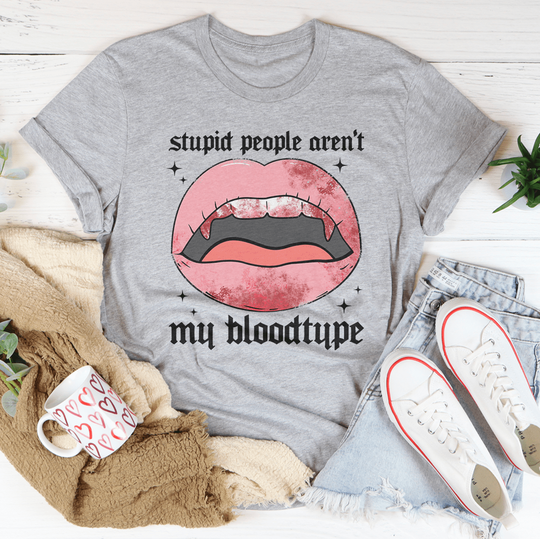 A black Halloween tee featuring the phrase 'Stupid People Aren't My Bloodtype' in bold white letters, made from 100% soft cotton.