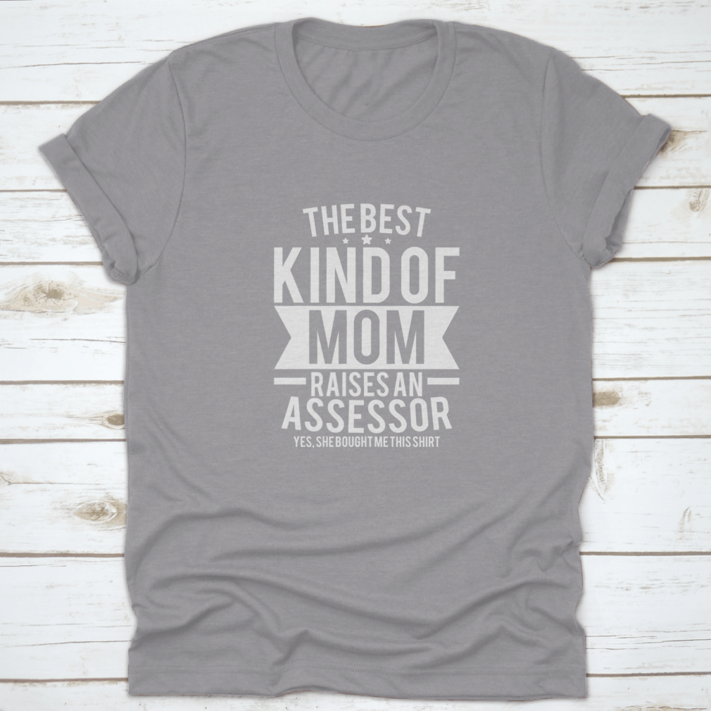 A stylish cotton shirt with the phrase 'The Best Kind Of Mom Raises An Assessor Yes, She Bought Me This Shirt' printed on it, showcasing a fun and loving message for mothers.