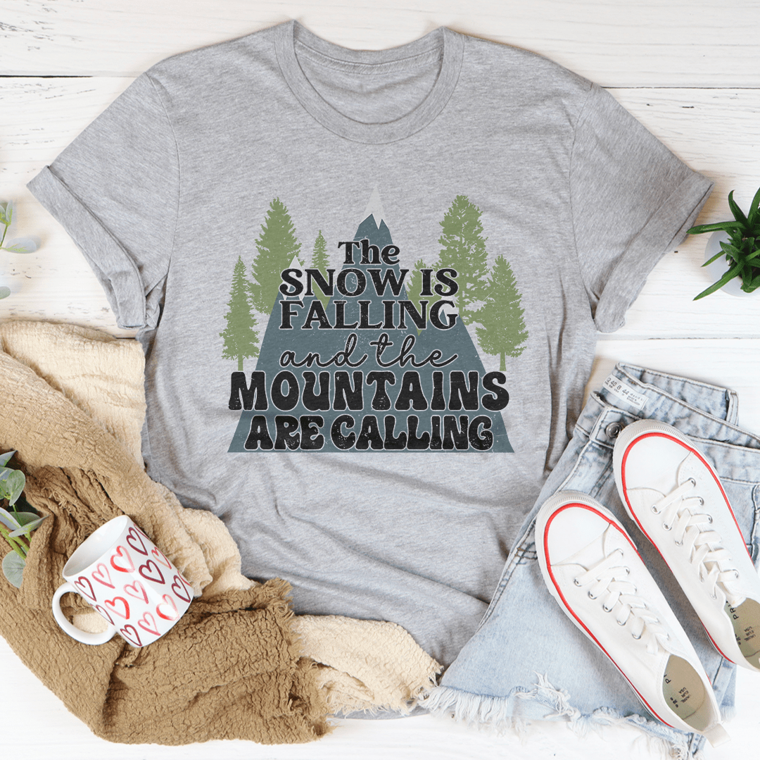 A festive tee featuring a snowy mountain design, made from 100% soft cotton, perfect for holiday celebrations.