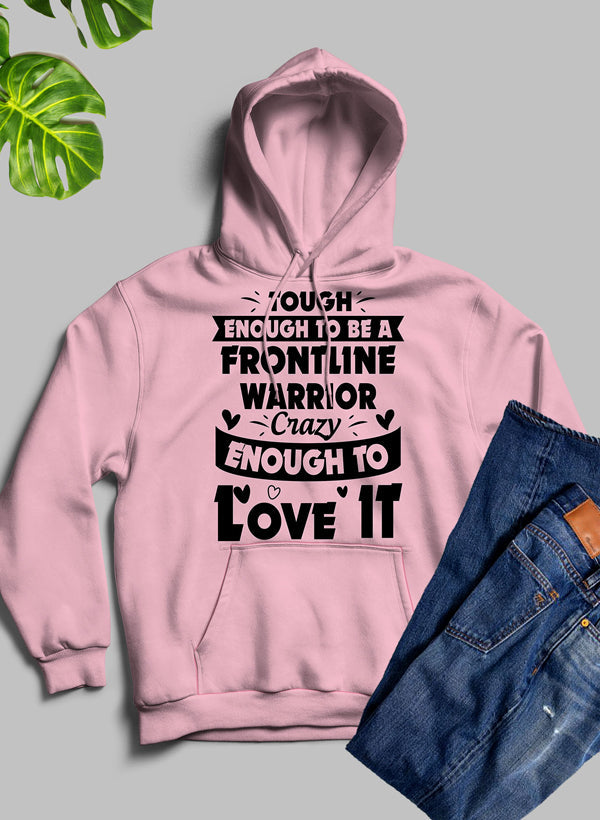 A cozy hoodie featuring a bold design that reads 'Tough Enough To Be A Frontline Warrior Crazy Enough To Love It', made from warm fleece blend material.