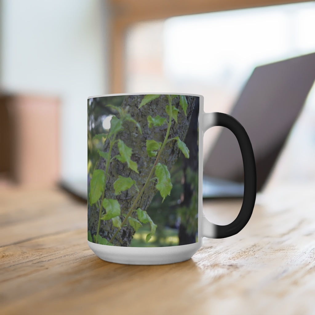 A color-changing ceramic mug featuring a tree stump and green leaves design, showcasing its vibrant colors when filled with hot liquid.