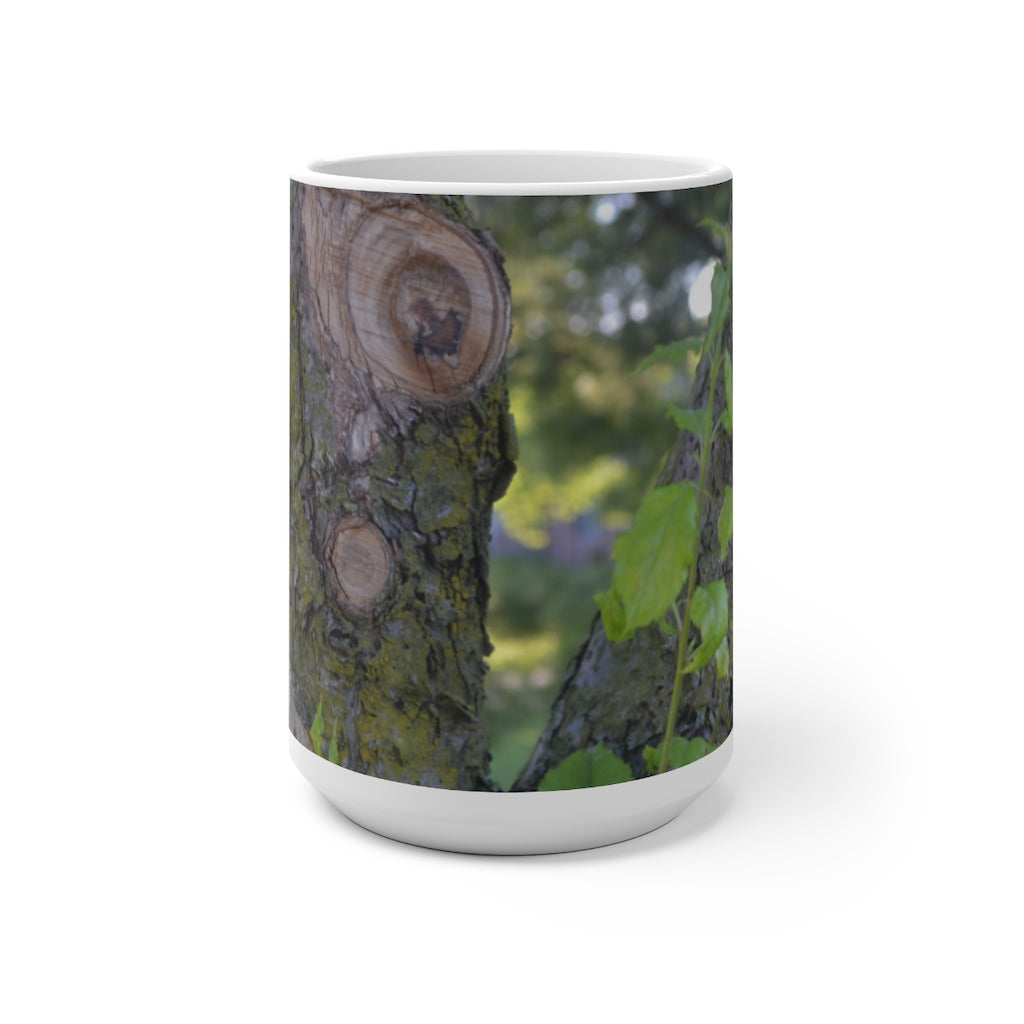 A color-changing ceramic mug featuring a tree stump and green leaves design, showcasing its vibrant colors when filled with hot liquid.