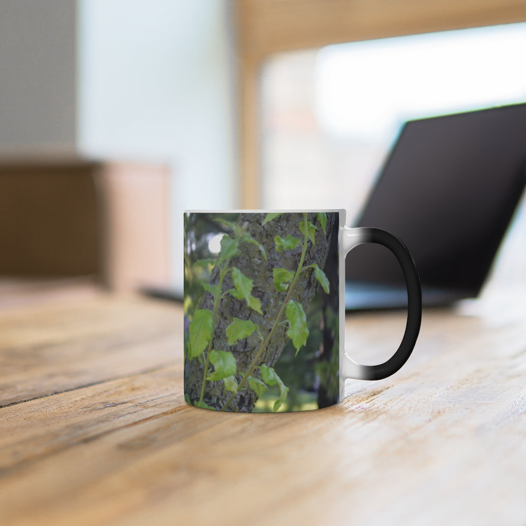 A color-changing ceramic mug featuring a tree stump and green leaves design, showcasing its vibrant colors when filled with hot liquid.