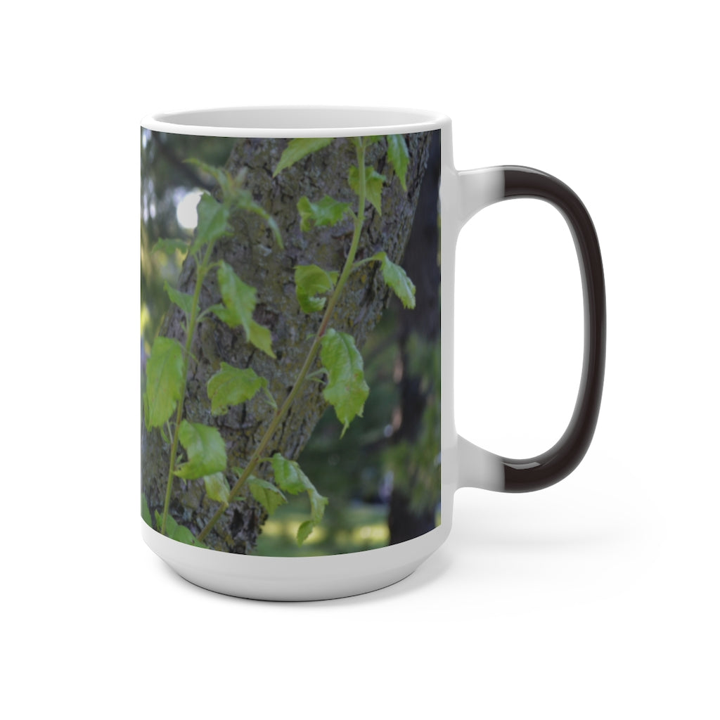 A color-changing ceramic mug featuring a tree stump and green leaves design, showcasing its vibrant colors when filled with hot liquid.
