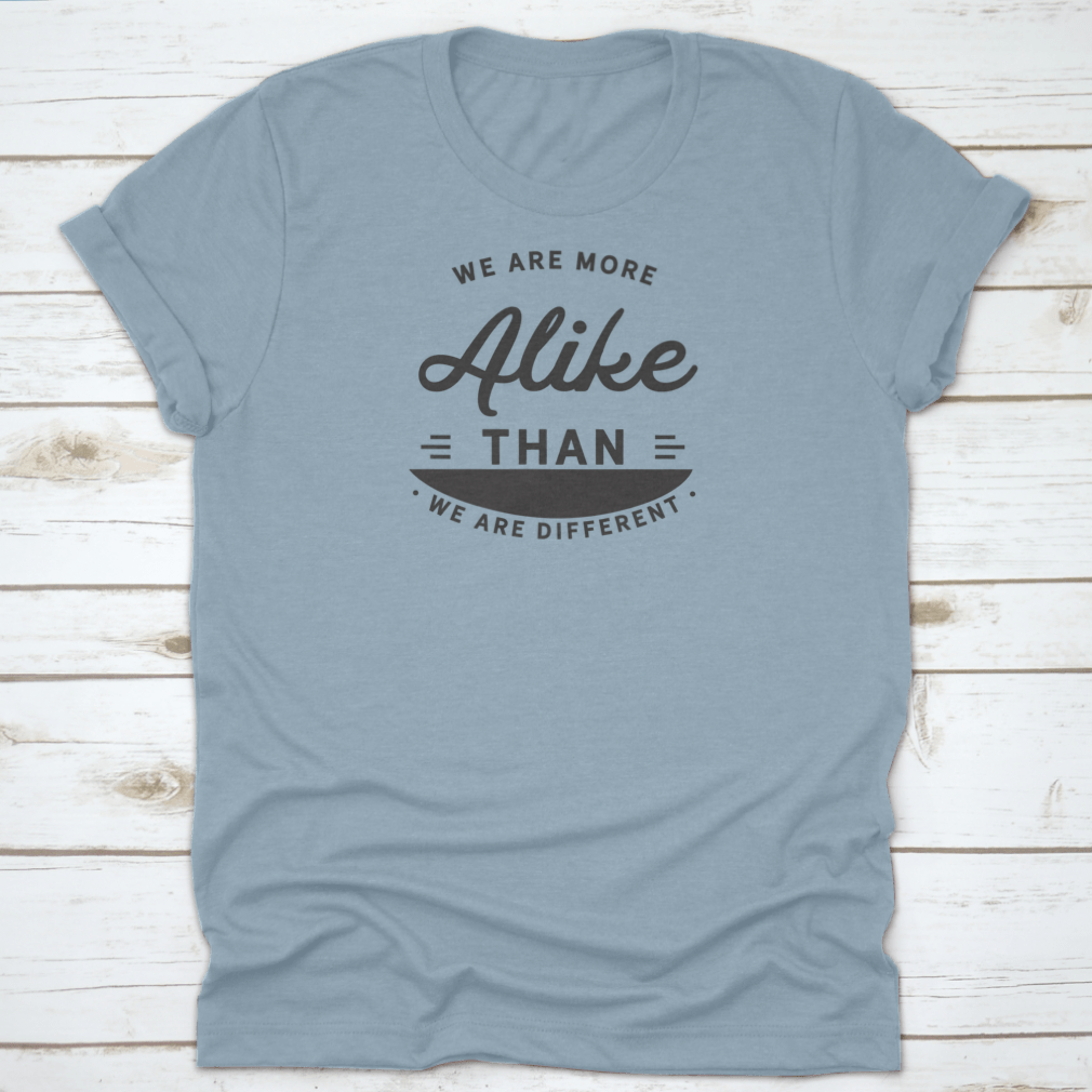 A motivational t-shirt featuring the phrase 'We Are More Alike Than We Are Different', made from soft cotton fabric.
